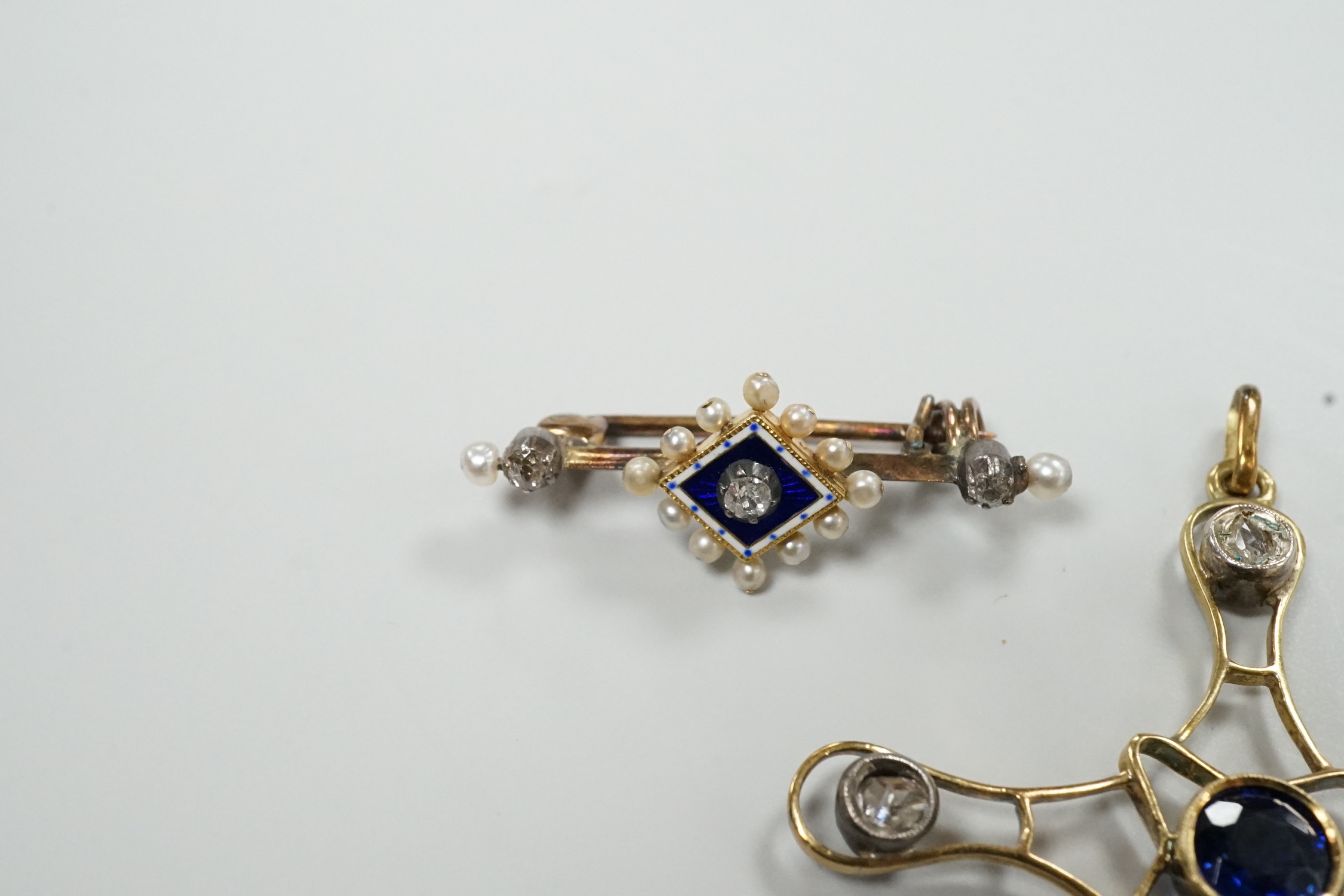 An Edwardian yellow metal, enamel and diamond chip set brooch, 30mm and a rose cut diamond and synthetic sapphire? set yellow metal cross pendant, gross weight 6.8 grams.